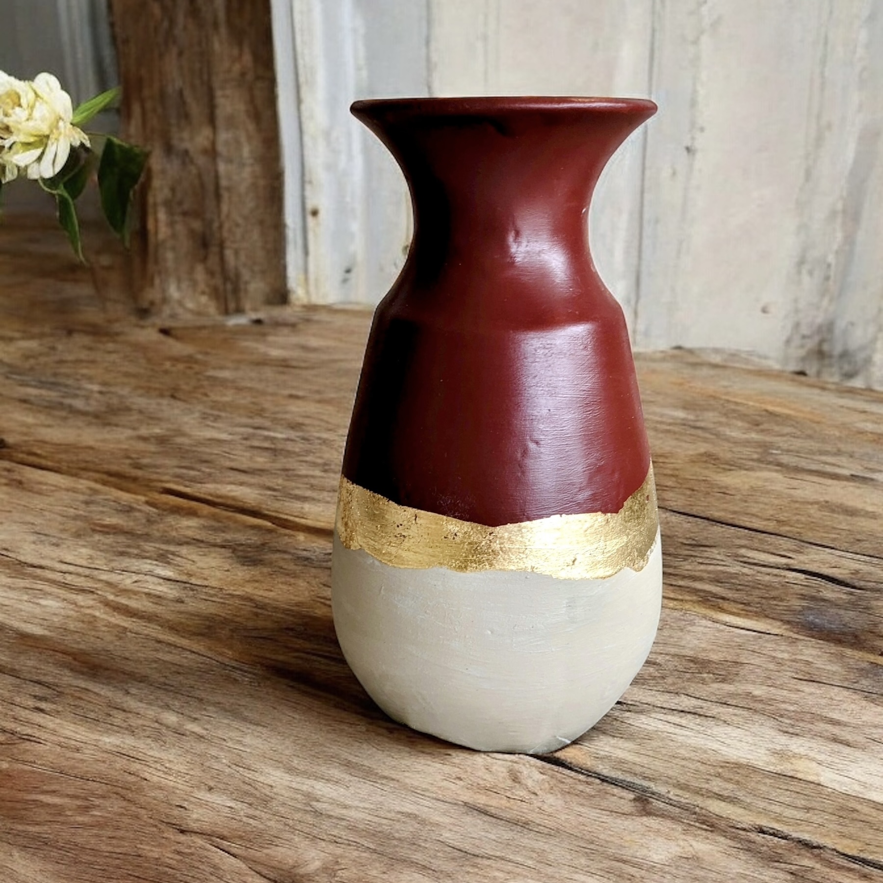 Vase beige et bordeaux avec un liseré en feuille d’or
