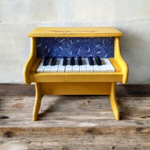 Petit piano jaune et tissu bleu et des motifs vague