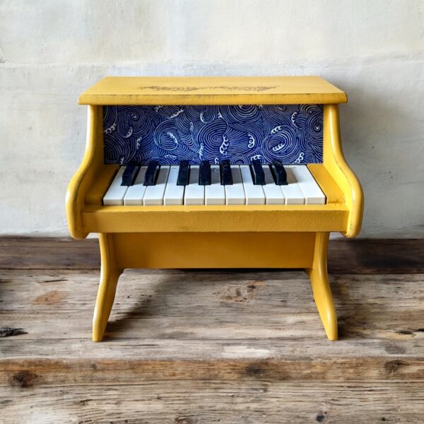 Petit piano jaune et tissu bleu et des motifs vague