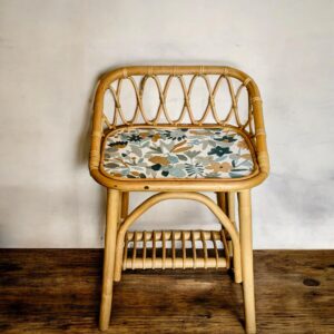 Table de chevet en rotin avec papier peint fleuri