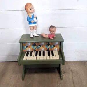 Détail du pochoir cire dorée sur le piano en bois vert printanier