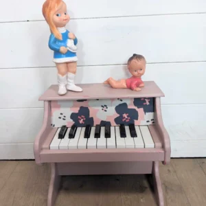 Détail du tissu à grosses fleurs sur le piano en bois rose poudré