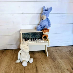 Détail du tissu bleu marine et doré sur le piano en bois blanc