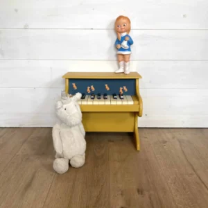 Détail du tissu renard sur le piano en bois jaune
