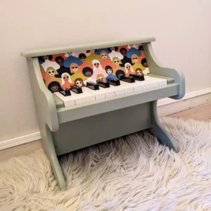 Détail du tissu visages colorés sur le piano en bois vert