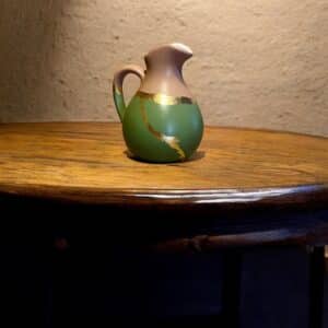 Pichet vert et rose poudré sur une table rustique