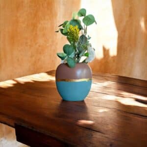 Vase marron glacé et gris bleu posé sur une table en bois rustique Avec un bouquet