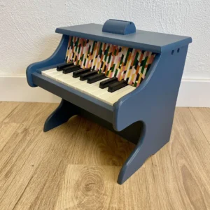 Piano en bois bleu nuit relooké à la main, détail du tissu coloré