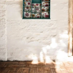 Détail du papier peint fleuri sur l'étagère murale verte