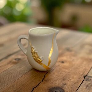 Pichet décoratif beige et doré avec moulures