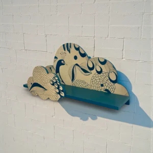 Détail du motif paon sur l'étagère murale bleu canard