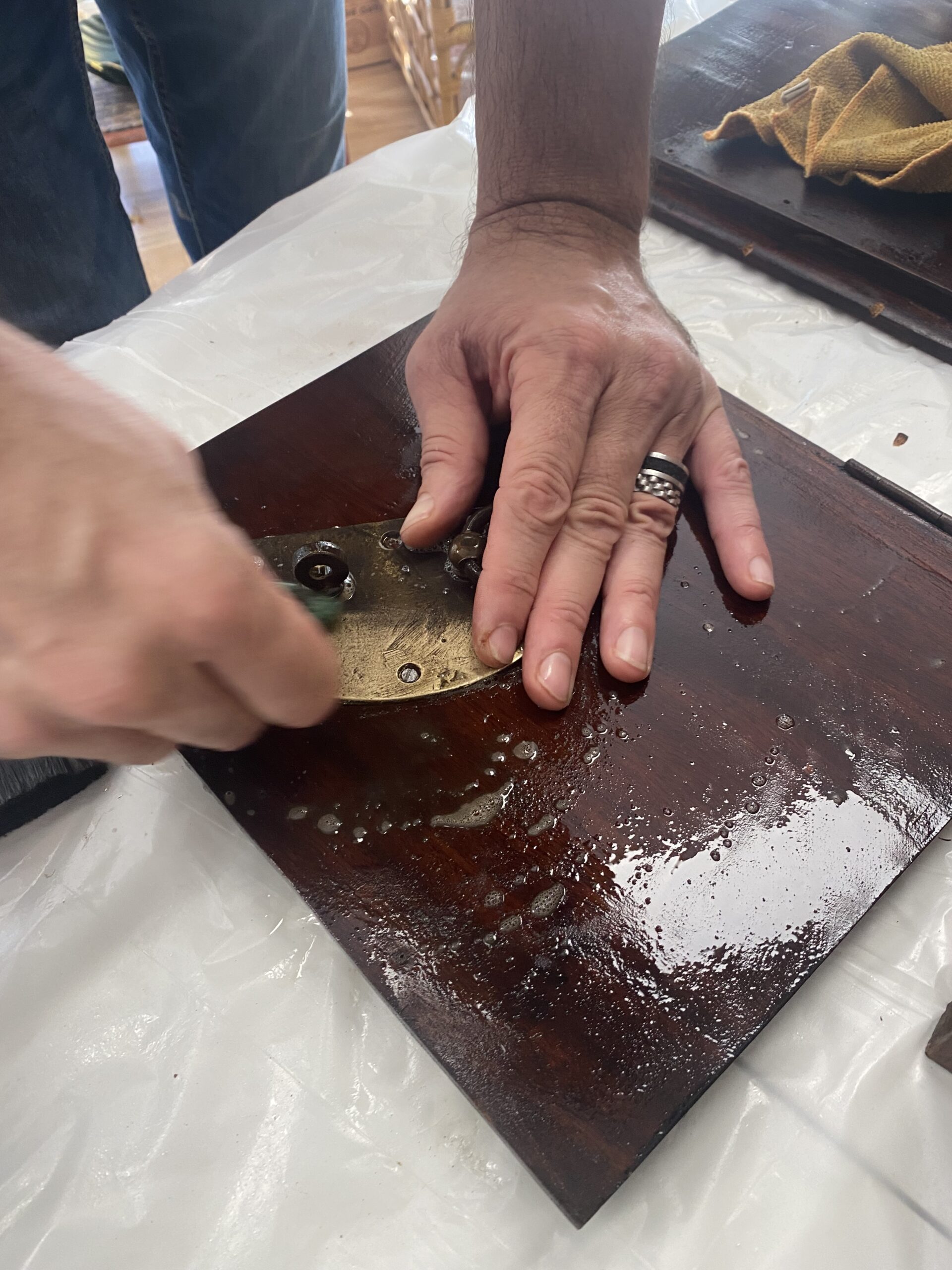 Mains en plein travail de relooking d'un meuble a l'atelier By Leo, Castelginest